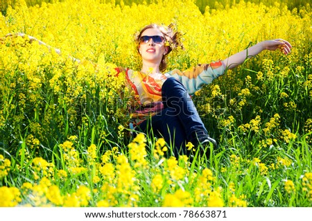 Young happy woman in yellow flowers