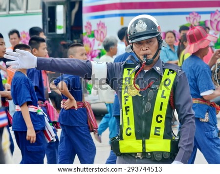 LOEI PROVINCE, THAILAND-Feb 2 :   Festival (Dog faay Ban ) Confident middle aged traffic police signaling stop gesture with car  in Dog Faay Ban Festival , Loei, Feb 2 ,,2015.