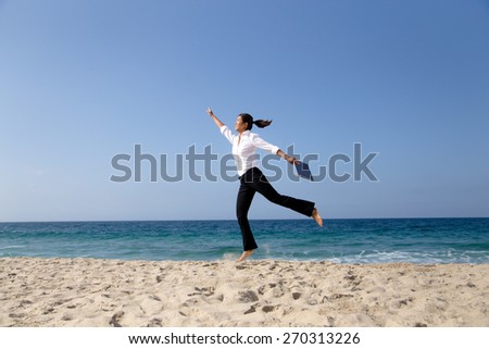 Asian woman in working outfit having fun with a laptop at beach