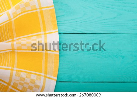 Yellow tablecloth on blue wooden background