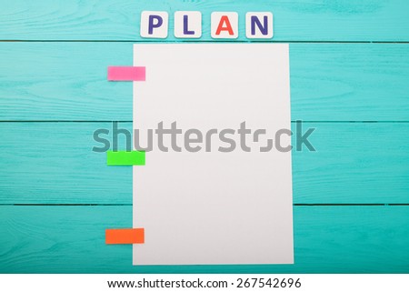 Word plan and paper with stickers on blue wooden background