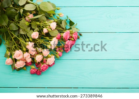 Pink and beige flowers on blue wooden background