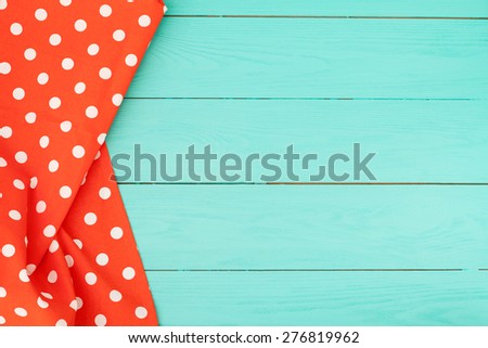Tablecloth in polka dots on blue wooden background