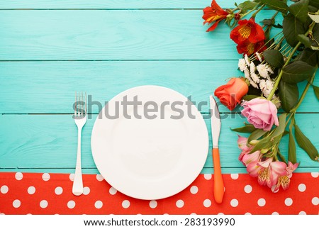 Festive dinner and flowers on blue wooden background