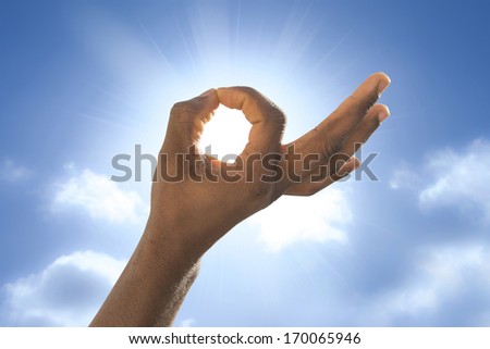 Man\'s hand in front of the sun