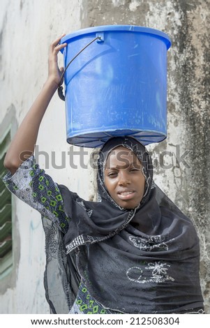Afro beauty carrying a bucket of water in a slug