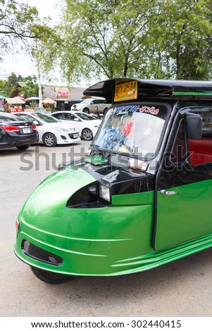 Ayutthaya Thailand - July 30 2015: Green auto rickshaw, Motorized tricycle park to waiting travelers at Wat Chaiwatthanaram, Ayutthaya. Side view.