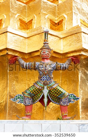 Giant demon guarding statue on golden pagoda at Wat Phra Kaew, Bangkok Thailand.