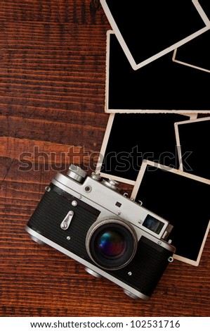 Top View of Vintage photo camera on wooden table plate with blank photo frames