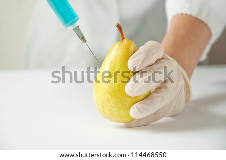 Genetic engineering laboratory, gmo food concept. Yellow pear with injection.