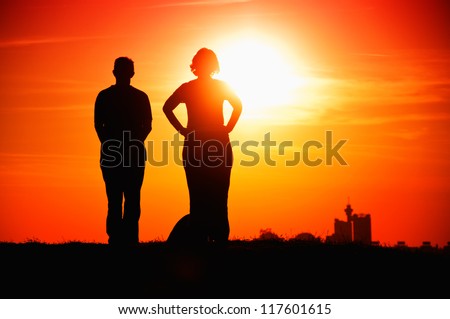 Couple sun gazing, man and woman performing a sun meditation.