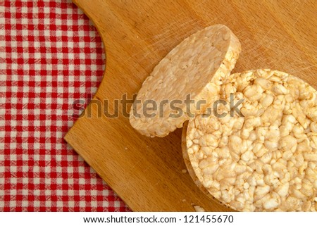 Rice cakes on wood plate over a kitchen table. Rice cakes are healthy dietary food product, top view.