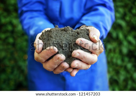 Agricultural worker holding a soil in cupped hands. Spring, growth, new life, ecology, environmental, nature preservation concept