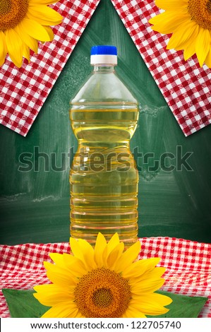 Sunflower oil bottle on a kitchen table. Yellow sunflowers in the background.