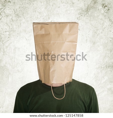 Shy man. Head in the paper bag. Man hidden behind the shopping bag.