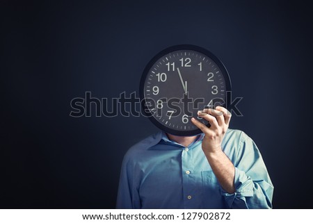 Businessman with black clock in front of his head, deadline concept. Not enough time to finish the job. Time management.