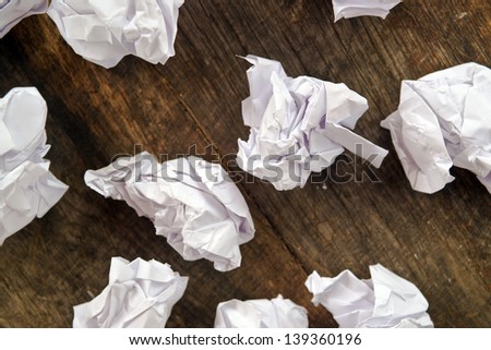 Crumpled paper on wood background. Pieces of white crumpled paper on old wooden table.