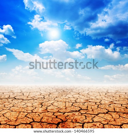 Dry desert land against a blue sky with clouds