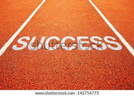 Success title on athletics all weather running track. Successful in sport concept.