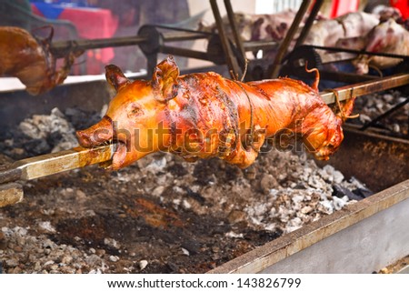 Whole roasted pig on a steel spit