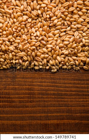 Wheat grains on wood background. Wheat grains texture, top view