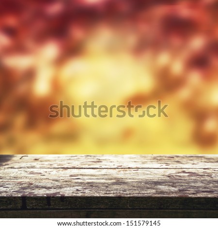 Autumn background. Empty old wooden table for product placement with blur autumn background