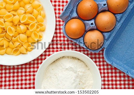Flour, eggs and pasta  on kitchen table, raw food ingredients.
