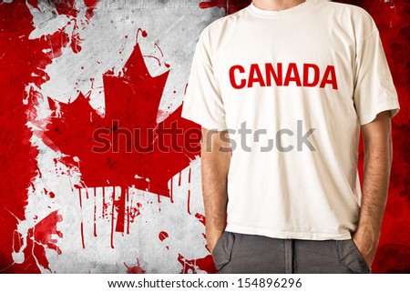 Man in white shirt with title CANADA, Canadian flag in background