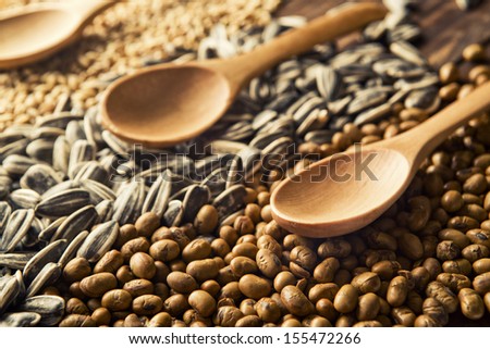 Wood spoons and cereal grains on wooden table