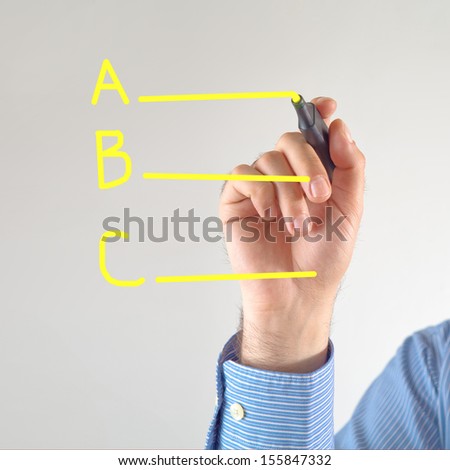 Different options. Businessman writing with yellow marker pen on the screen