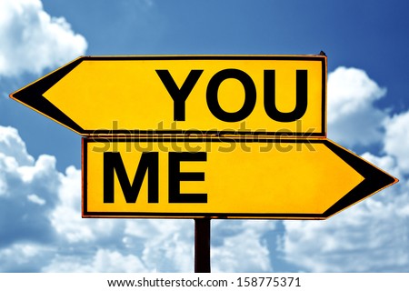 Choosing between You and me. Two opposite signs against blue sky background.