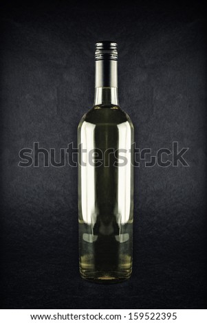 Bottle of wine. White wine in bottle on dark background