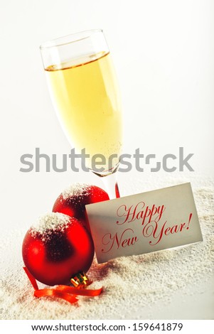 Happy New Year card. White wine and christmas balls with greeting card. New Year\'s Eve decoration.