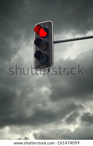 Stop light, the red traffic light on a cloudy day