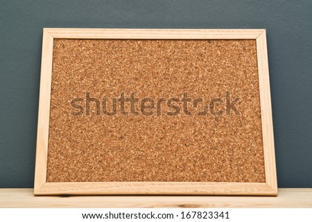 Empty cork memory board on wooden cabinet in a room with copy space.