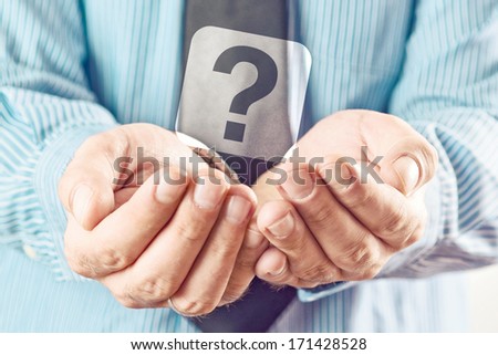 Businessman holding question mark. Businessman begging for answers with his cupped hands.