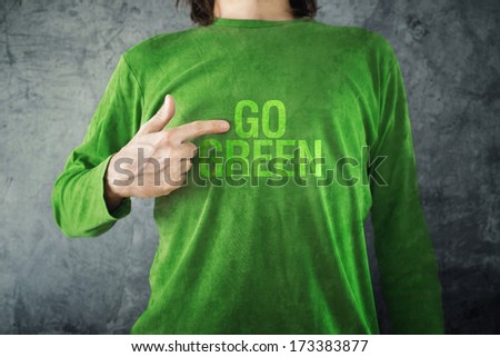 Man pointing to GO GREEN title printed on his shirt, healthy lifestyle concept.