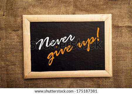 Never give up, motivational message on blackboard.