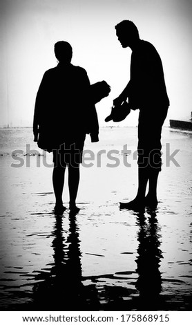 Couple talking on the street. Urban scenery after heavy summer rain. Black and white image.