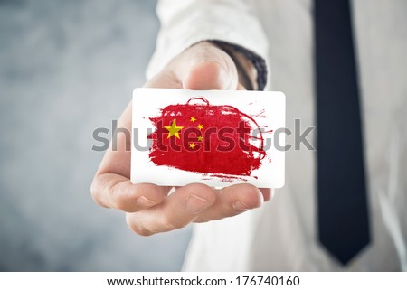 Chinese Businessman holding business card with China Flag. International cooperation, investments, business opportunities concept.