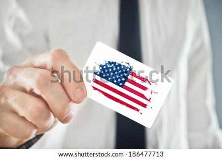 American Businessman holding business card with USA Flag. International cooperation, investments, business opportunities concept.