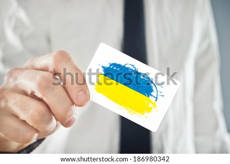 Ukrainian Businessman holding business card with Ukraine Flag. International cooperation, investments, business opportunities concept.