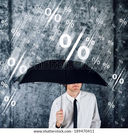 Businessman with umbrella protecting himself from percentage rain. Concept of share profits; credit; money loan interest; finance and economy.