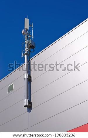 GSM Antenna. Mobile phone signal repeater system installed on the roof top of industrial building.