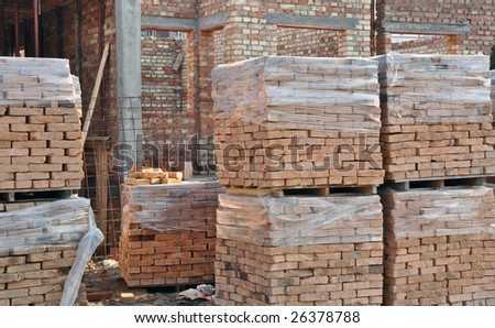 Pile of bricks. Building a private house, construction site. Bricks and other construction material.
