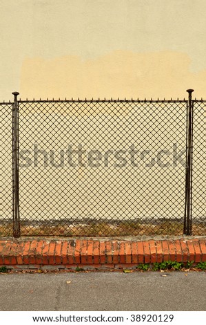 detail of a steel fence against a white concrete wall.