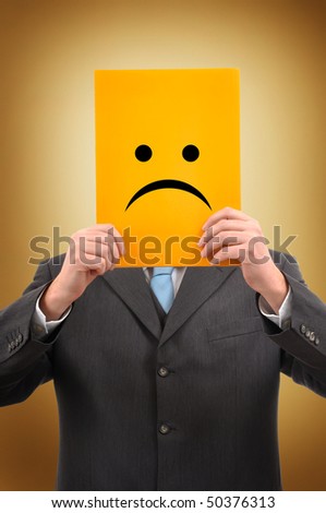 Sad businessman. Businessman in gray suite holding a yellow folder with sad face drawn on it