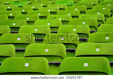 Stadium seats. Empty green plastic stadium seats, open door sports arena.