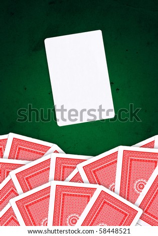 Joker card and other playing cards over green, grungy background