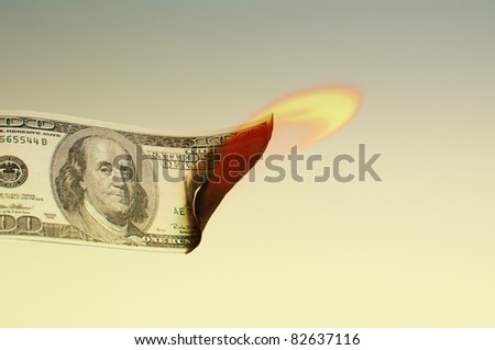 Hundred dollar bill is burning, close up image.